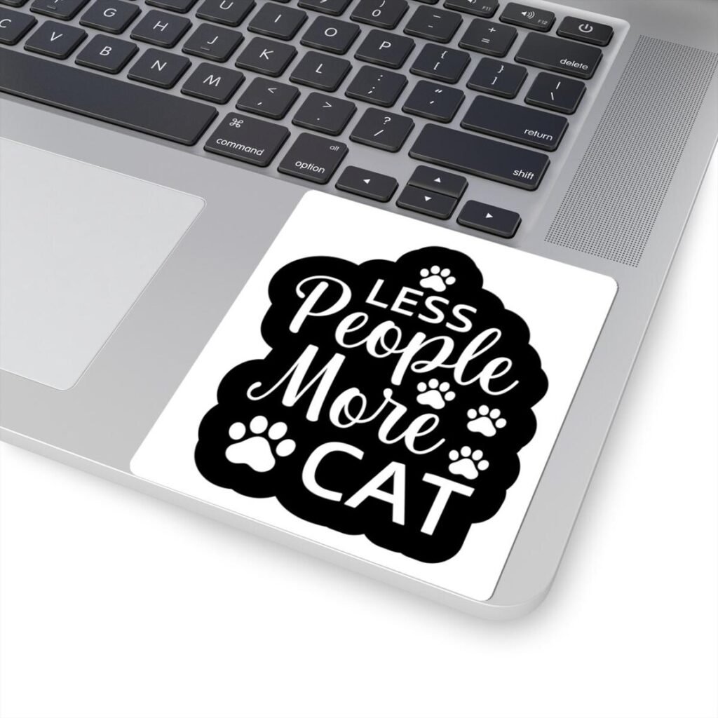 Photo of Siamese cat sticker on a laptop with a funny quote saying "Les People More Cat"